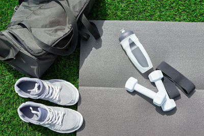 Sneakers and sport items on gray background top view