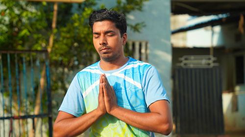 Healthy man sitting on mat and meditation with lotus pose in morning. wellness, fitness, exercise an