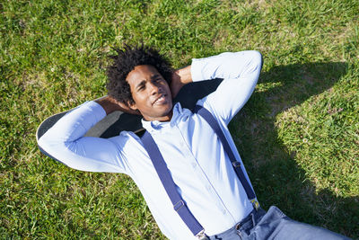 Portrait of young woman sitting on grassy field