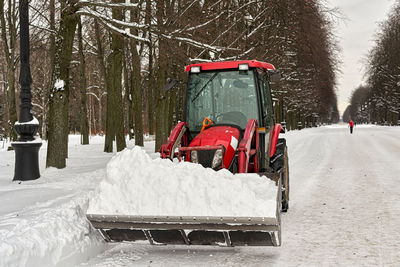 Snow covered road amidst trees during winter