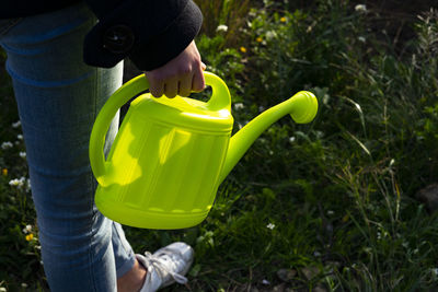 Gardener taking a green watering can.