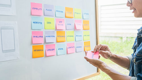 Low angle view of woman working on wall