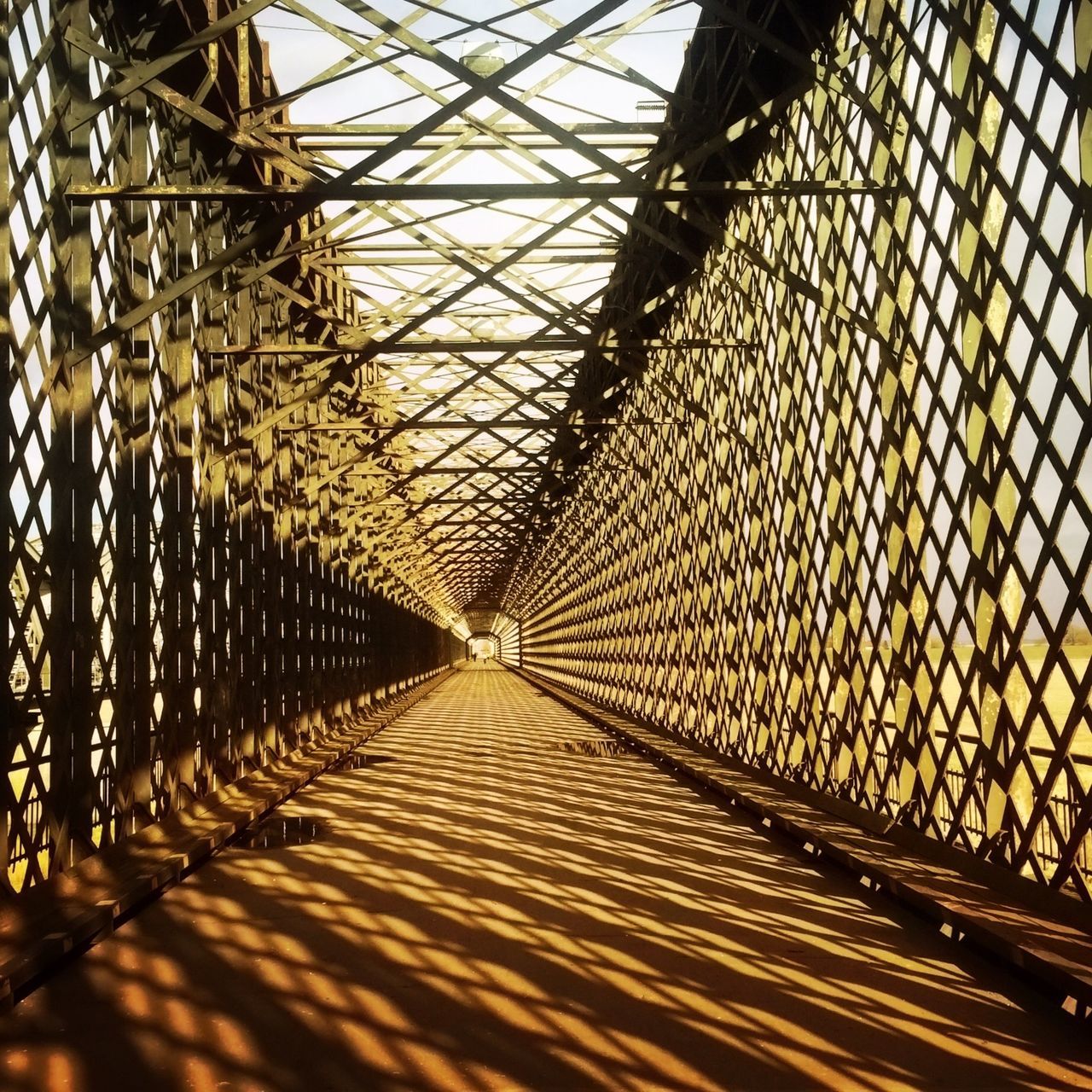 the way forward, diminishing perspective, metal, built structure, vanishing point, architecture, connection, pattern, transportation, indoors, bridge - man made structure, chainlink fence, metallic, long, no people, day, fence, protection, railing, footbridge