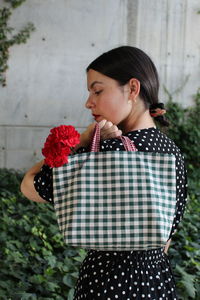 Close-up of woman holding bag standing outdoors