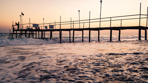 Scenic view of beach against clear sky during sunset