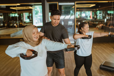 Portrait of young woman exercising in gym