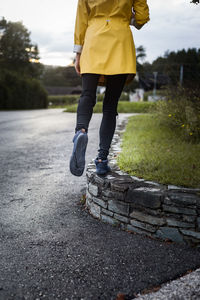 Low section of woman walking on road