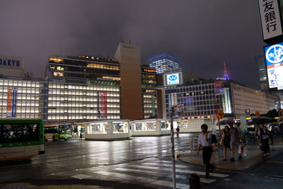 People in illuminated city at night