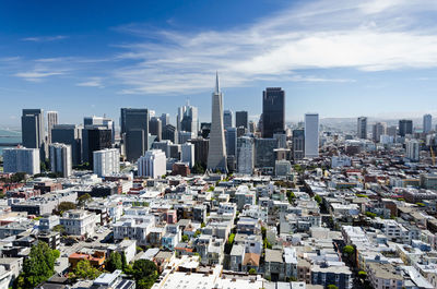 Aerial view of buildings in city against sky