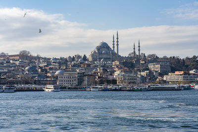 View of buildings in city against cloudy sky