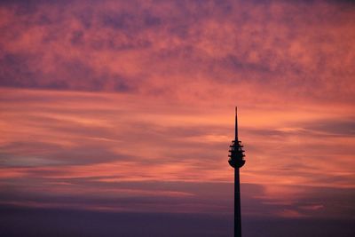 Silhouette communications tower against sky during sunset