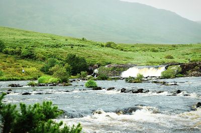 View of stream flowing through rocks