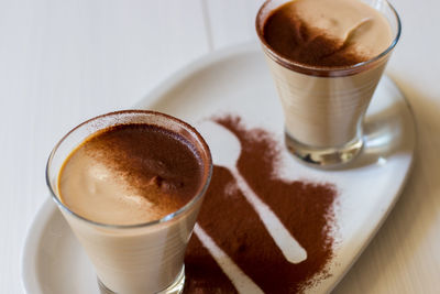 Coffee ricotta, spoon dessert in glass cup served in a white plate