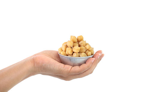 Close-up of hand holding ice cream against white background