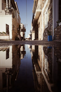 Canal amidst buildings against sky in city