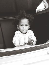 Portrait of cute girl sitting in car