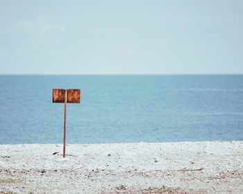 Lifeguard hut on beach against sky