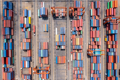 Warehouse stacking containers group in a row and cranes load unloading, distribution center 