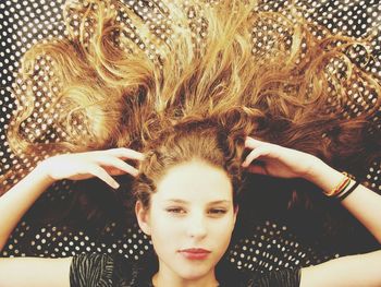 Directly above shot of young woman with fanned out hair on bed