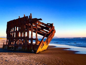 Abandoned beach against clear blue sky