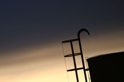 Low angle view of silhouette ladder against clear sky at sunset