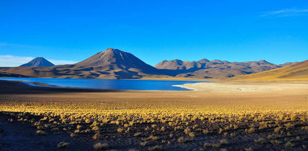 Scenic view of mountains against blue sky