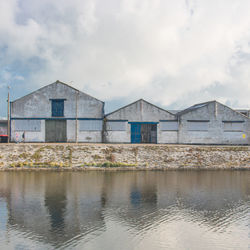 Warehouses by sea against sky in a harbour