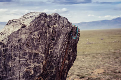 Beige backpack, bottle of water and straw hat on on top of the mountain. active travel concept.