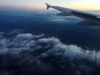 Cropped image of airplane flying over cloudscape