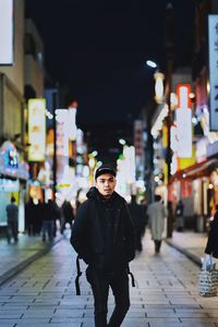 Full length of man standing on street at night