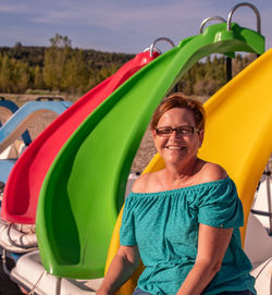 Portrait of smiling senior woman sitting at playground