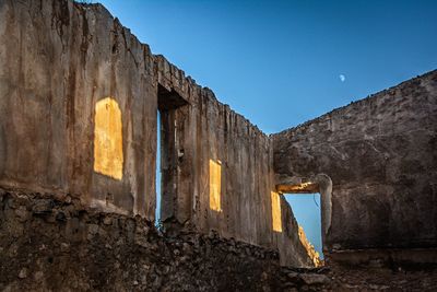 Low angle view of old building against clear blue sky