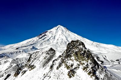 Scenic view of snowcapped mountains against clear blue sky