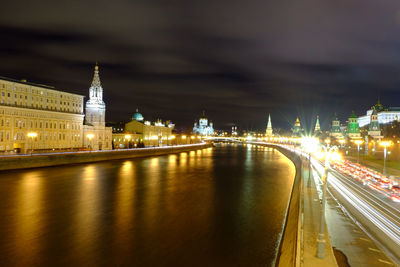 High angle view of river amidst illuminated city at night