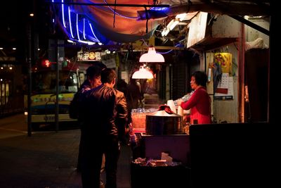 People standing in market at night