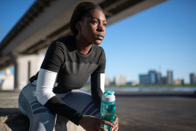African american sportswoman with water resting