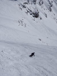 Rear view of person skiing on snowcapped mountain