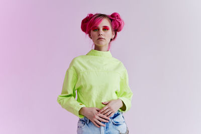 Young woman standing against blue background