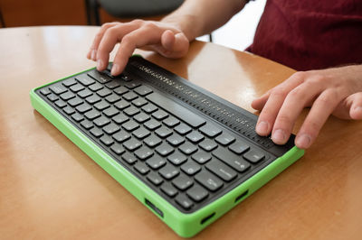 Midsection of woman using laptop on table