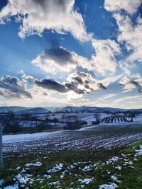 Scenic view of snow covered land against sky