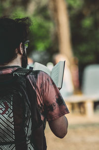 Rear view of man holding book