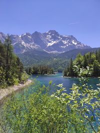 Scenic view of lake by mountains against clear sky