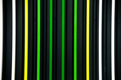 Full frame shot of colorful fence against black background