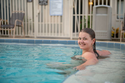 Portrait of smiling woman swimming in pool