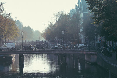 Scenic view of river in city against sky