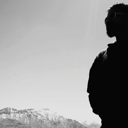 Side view of silhouette woman looking at mountain against sky