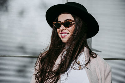 Portrait of young woman wearing sunglasses standing outdoors