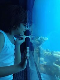 Close-up of woman standing and looking at sea life