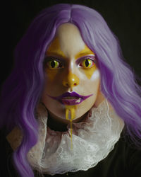 Portrait of woman with purple face against black background