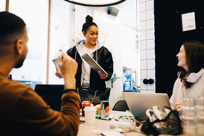 Happy young multi-ethnic programmers discussing at small creative office